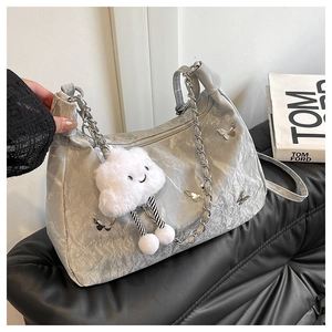 Close-up of grey crinkled tote with silver butterfly charms and plush cloud pendant