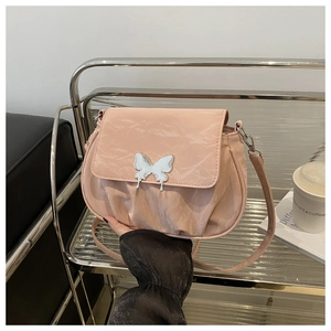 Close-up of pink pleated handbag featuring an elegant silver butterfly metal buckle clasp