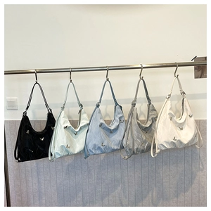 Five pleated shoulder bags in various colors featuring 3D butterfly metal ornaments