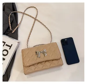 Quilted beige crossbody bag size comparison with a smartphone and chain strap detail