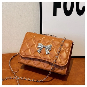 Detail of brown quilted shoulder bag with silver bow buckle and woven metal chain strap