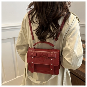 Detail of dark red vintage faux leather backpack with heart motif and silver rivets