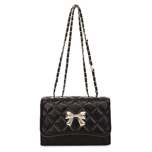 Elegant black quilted crossbody bag with silver bow clasp and woven chain strap