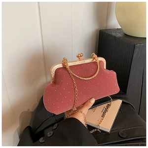 Detail of dusty rose velvet shell bag with white dots and gold heart-shaped clasp