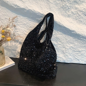 Sparkly black sequin tote bag with matching mini round pouch on a sleek black table