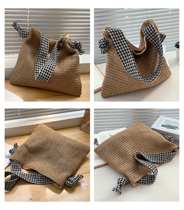 Detail of woven straw tote bag featuring stylish houndstooth straps and texture