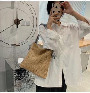 Detail of beige woven tote bag with a striking black and white houndstooth wide strap