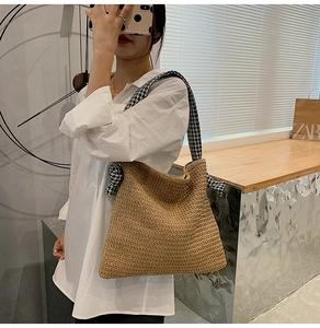 Detail of hand-woven straw shoulder bag with stylish black and white houndstooth strap