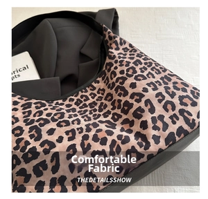 Close-up of leopard print shoulder bag featuring soft textured fabric and black lining