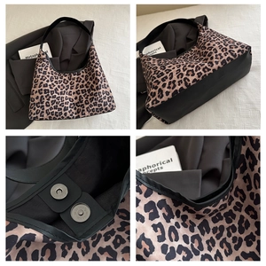 Detail of leopard print tote featuring magnetic closure and premium black leather patchwork