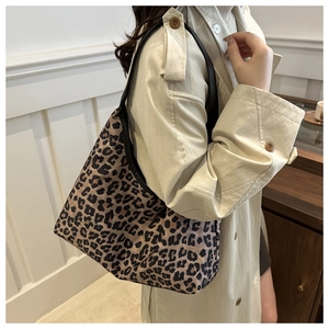 Close-up of leopard print canvas tote bag featuring comfortable black wide shoulder strap