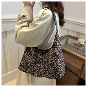 Detail of leopard print hobo bag with dark leather strap on casual trench coat