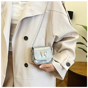 Détail du mini sac argenté avec fermoir papillon métallique et fine bandoulière chaîne