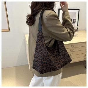 Vue détaillée du sac cabas léopard tendance avec des anses d'épaule en cuir noir de qualité