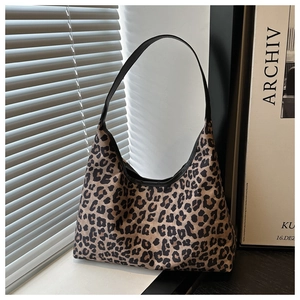 Detail shot of leopard print hobo bag with black leather strap and crescent shape