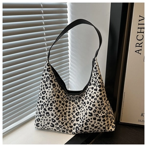 Detailed view of the leopard print pattern and black strap on this trendy hobo bag