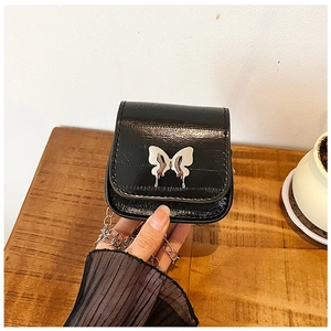 Gros plan détaillé d'un mini sac bandoulière noir en cuir PU avec boucle papillon