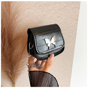 Détail du mini sac selle avec ornement papillon argenté et texture peau d'anguille