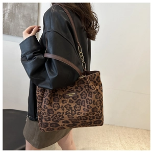 Detail of leopard print tote bag with brown leather and gold chain shoulder strap