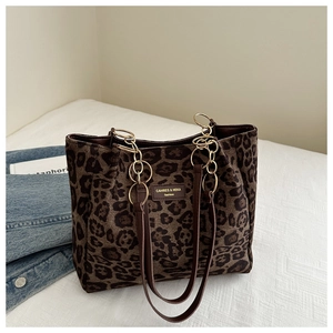 Detail of leopard print suede tote bag with brown leather straps and gold metal chain links