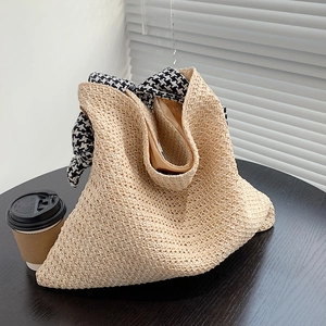 Minimalist straw woven tote bag with a houndscarf handle for summer beach vacation use