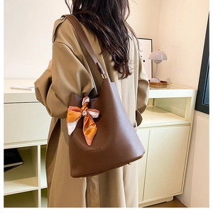 Brown lychee leather bucket bag with printed silk scarf detail and long shoulder strap