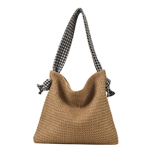 Minimalist woven straw shoulder bag with stylish black and white houndstooth strap and knots
