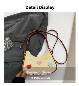Detail of hobo bag showing beige woven texture and five colorful stitched heart patches