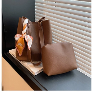 Detail of dark brown lychee leather bucket bag with printed scarf and inner pouch