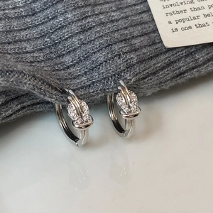 Close-up of silver knot earrings with micro-paved cubic zirconia crystals for women