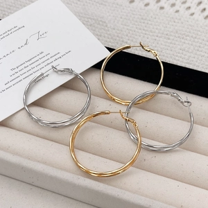 Minimalist double layer hoop earrings in gold and silver finish on velvet display