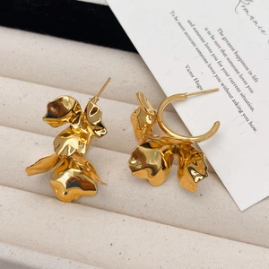Macro shot of 18K gold layered flower petal earrings in a luxury jewelry box
