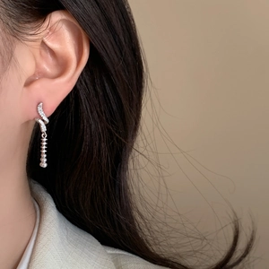 Silver geometric spiral earrings with zircon accents and dangling pearls on model