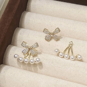 Elegant gold bow earrings with detachable pearl drops in a velvet jewelry box