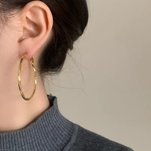 Elegant gold twisted hoop earrings for women featuring a minimalist oversized design