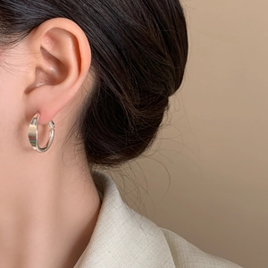Orecchini a cerchio geometrici minimalisti in argento con finitura lucida su modella