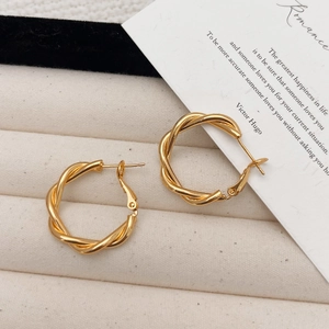 Créoles torsadées dorées brillantes présentées dans un écrin à bijoux rétro chic