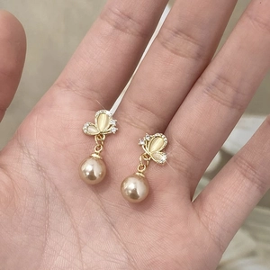 Elegant gold butterfly earrings with champagne cat eye stone and hanging pearl drop