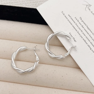 Boucles d'oreilles créoles torsadées mates argentées dans une boîte cadeau
