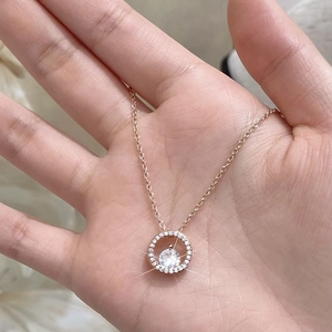 Collier cercle en or rose avec pendentif en zircon scintillant posé dans la paume