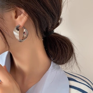 Boucles d'oreilles créoles argentées avec design multicouche et finition métallique