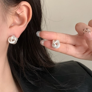 Minimalist silver twist knot stud earrings with a matte brushed finish for daily wear