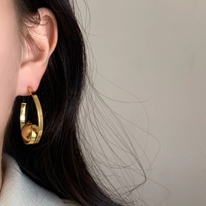 Minimalist gold C-shaped geometric hoop earrings with a metallic ball bead accent
