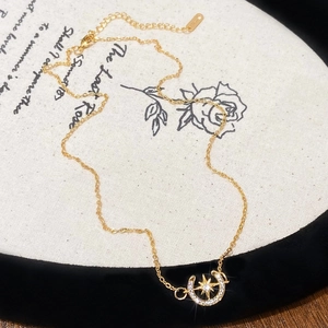 Détail du collier étoile et lune en or avec zircons cubiques sur un fond de toile décoratif