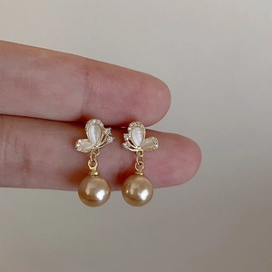 Elegant gold butterfly earrings with white cat-eye stones and champagne pearl pendants