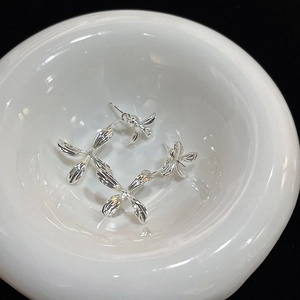 Boucles d'oreilles fleurs argentées avec finition polie sur une assiette blanche épurée