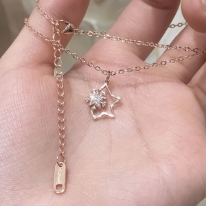 Hand holding rose gold snowflake star pendant necklace with cubic zirconia inlay