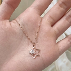 Sparkling zircon snowflake and star pendant necklace in rose gold finish on a fine chain