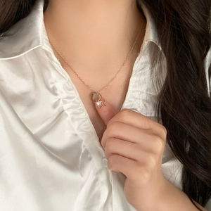Elegant rose gold star pendant necklace with sparkling zircon on a white satin blouse