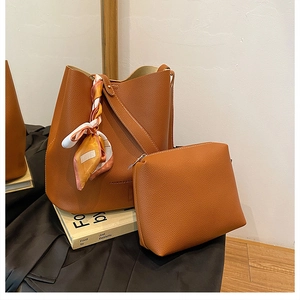 Detail view of large brown litchi pattern leather bucket bag set with decorative silk scarf